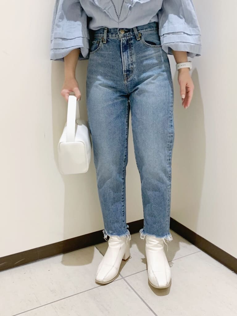 ブルー系のデニムパンツ、ブルー系のシャツ/ブラウス、ホワイト系のハンドバッグを着用したレディースの冬コーディネートの7枚目の写真