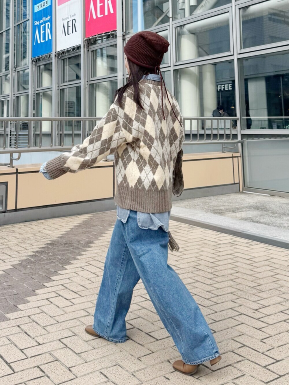 ベージュ系のニット/セーター、ブルー系のシャツ/ブラウス、ブルー系のデニムパンツを着用したレディースの秋コーディネートの4枚目の写真