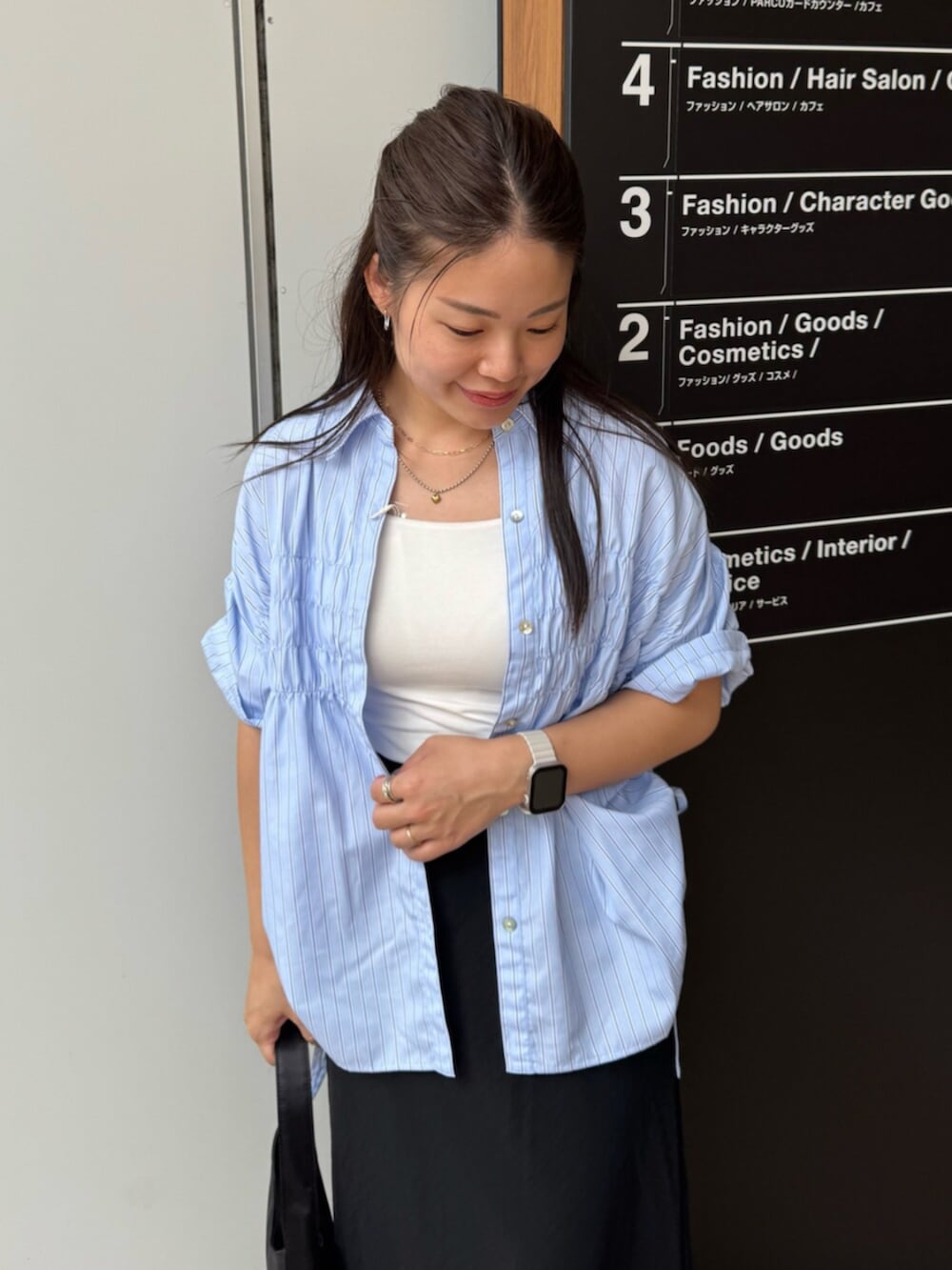 ブラック系のハンドバッグ、ブルー系のシャツ/ブラウス、ブラック系のスカートを着用したレディースの夏コーディネートの6枚目の写真