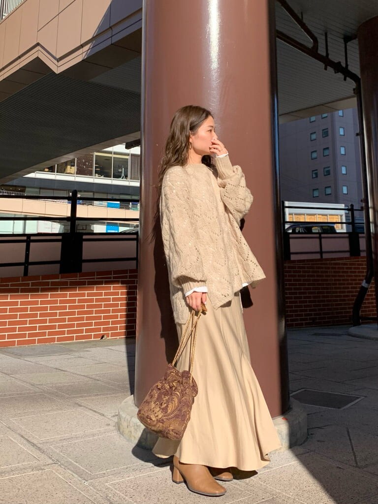 ブラウン系のハンドバッグ、ベージュ系のスカート、ベージュ系のニット/セーターを着用したレディースの秋コーディネートの4枚目の写真