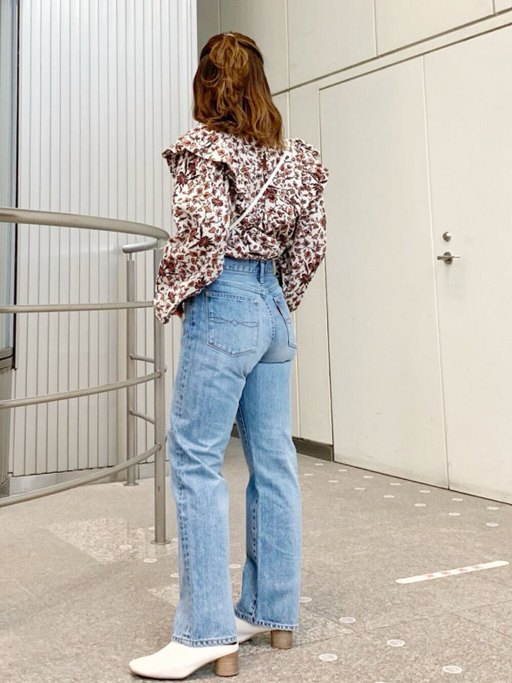 ブルー系のデニムパンツ、ホワイト系のボディバッグ/ウエストポーチ、ホワイト系のシャツ/ブラウスを着用したレディースの春コーディネートの2枚目の写真