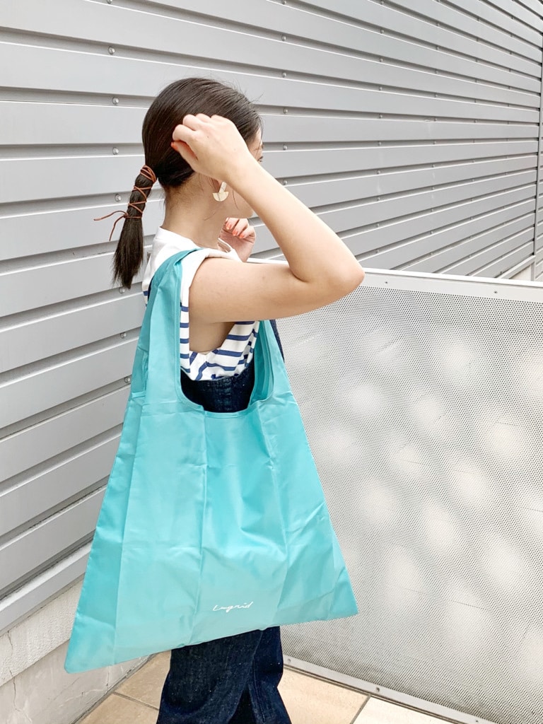 ブルー系のつなぎ/オールインワン、ブラウン系のサンダル、ブルー系のハンドバッグを着用したレディースの春コーディネートの6枚目の写真