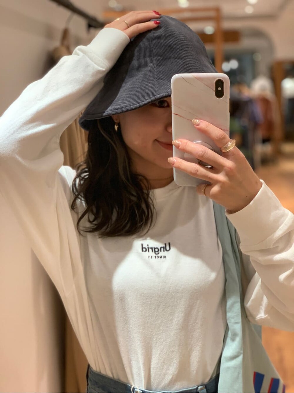 ホワイト系のTシャツ/カットソー、ブルー系のデニムパンツ、ブルー系のエコバッグ/サブバッグを着用したレディースの夏コーディネートの2枚目の写真