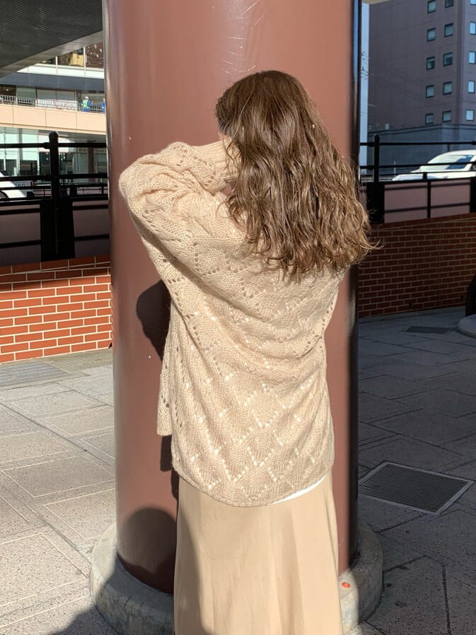 ブラウン系のハンドバッグ、ベージュ系のスカート、ベージュ系のニット/セーターを着用したレディースの秋コーディネートの3枚目の写真