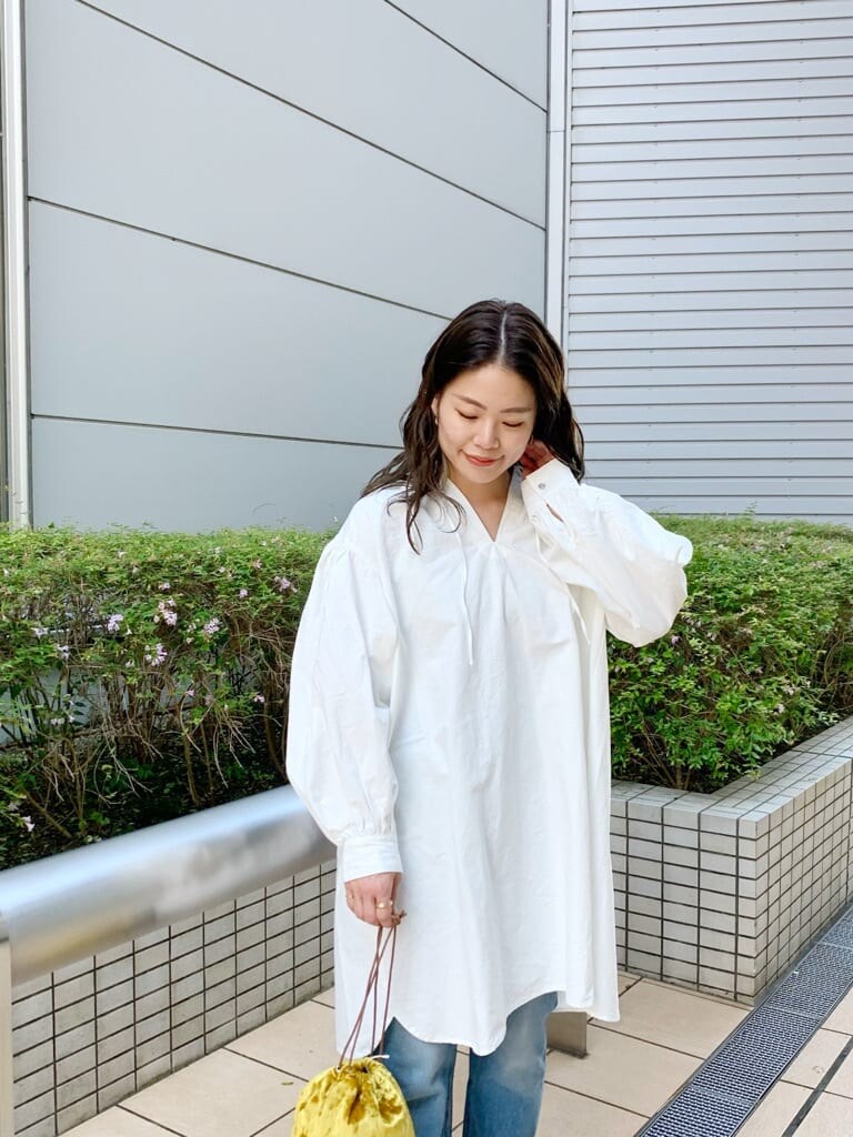 ベージュ系のブルゾン、ホワイト系のワンピース、イエロー系のハンドバッグを着用したレディースの夏コーディネートの3枚目の写真