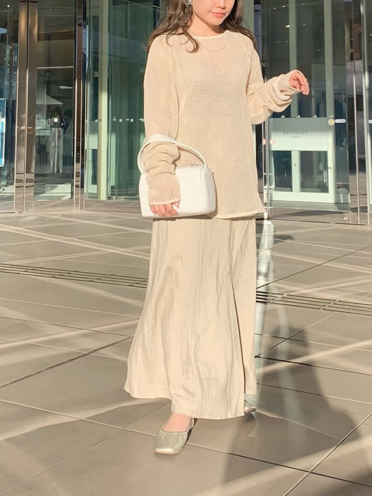 ホワイト系のハンドバッグ、ベージュ系のスカート、ホワイト系のTシャツ/カットソーを着用したレディースの春コーディネートの4枚目の写真