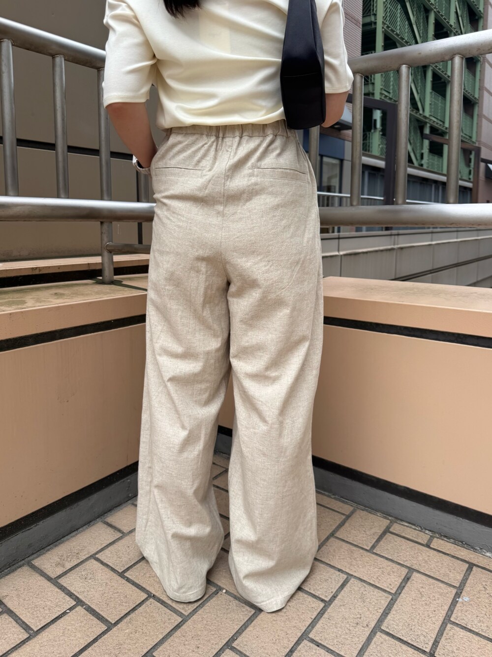 ホワイト系のTシャツ/カットソー、ベージュ系のその他パンツ、ブラック系のハンドバッグを着用したレディースの夏コーディネートの10枚目の写真