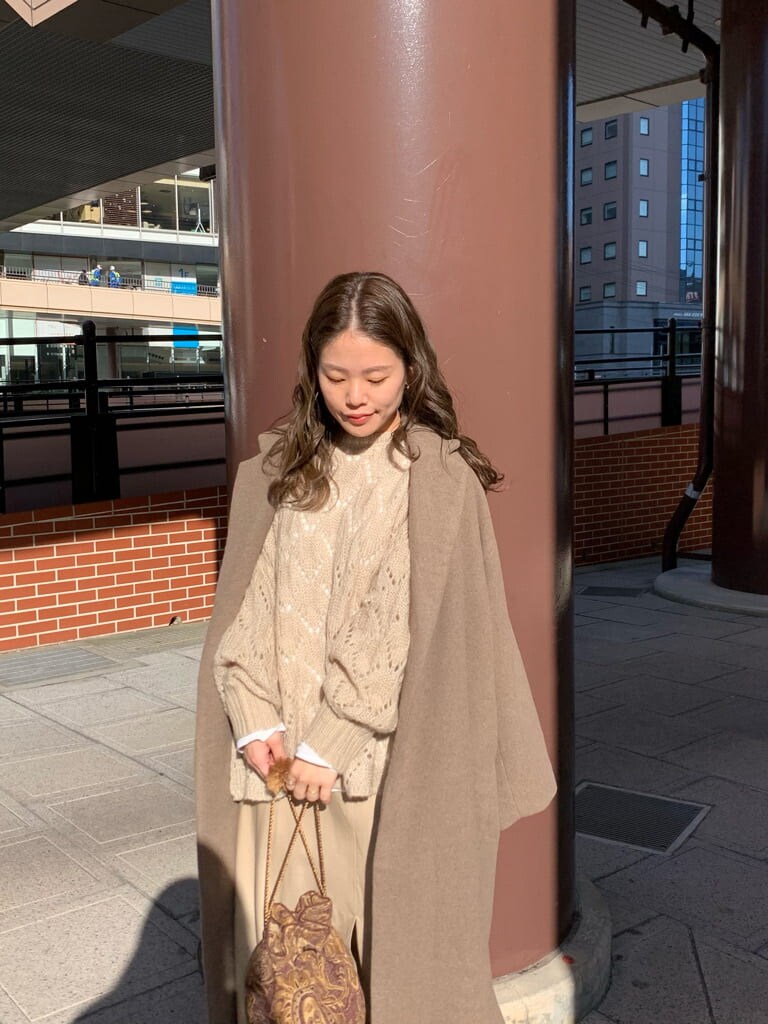 ベージュ系のスカート、ベージュ系のニット/セーター、ブラウン系のハンドバッグを着用したレディースの秋コーディネートの5枚目の写真