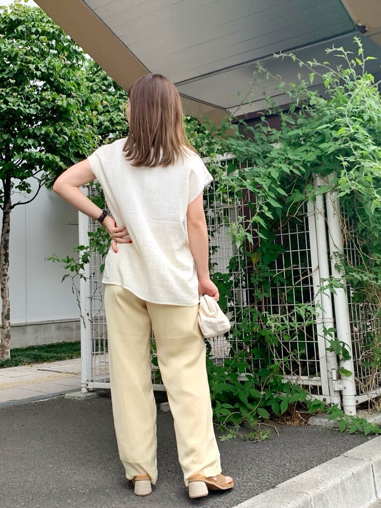 ホワイト系のクラッチバッグ、ホワイト系のシャツ/ブラウス、ブラウン系のサンダルを着用したレディースの夏コーディネートの3枚目の写真