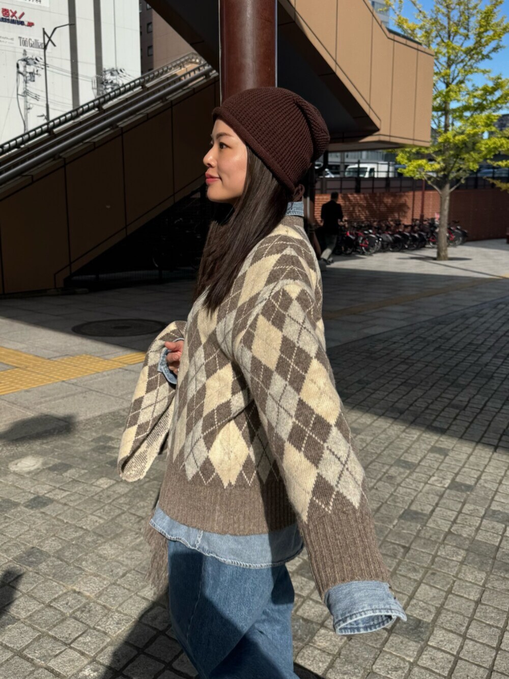 ベージュ系のニット/セーター、ブルー系のシャツ/ブラウス、ブルー系のデニムパンツを着用したレディースの秋コーディネートの6枚目の写真