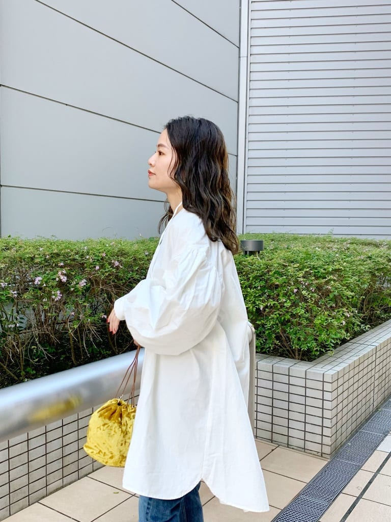 ベージュ系のブルゾン、ホワイト系のワンピース、イエロー系のハンドバッグを着用したレディースの夏コーディネートの4枚目の写真