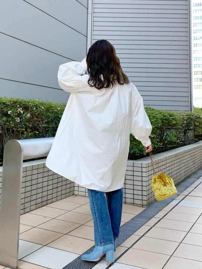 ベージュ系のブルゾン、ホワイト系のワンピース、イエロー系のハンドバッグを着用したレディースの夏コーディネートの2枚目の写真