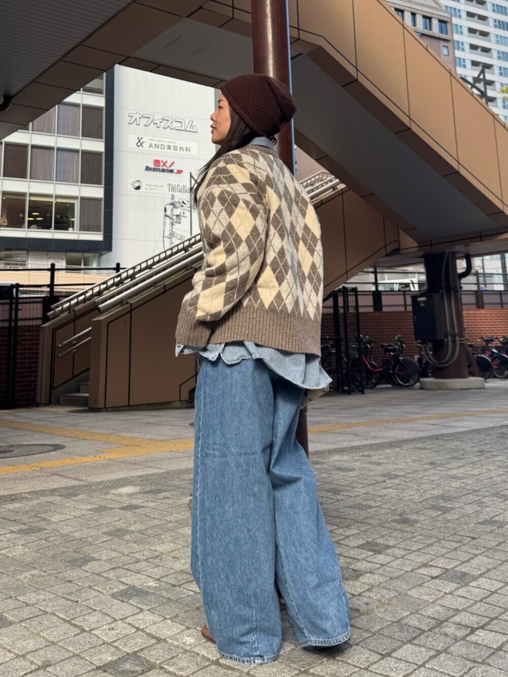 ベージュ系のニット/セーター、ブルー系のシャツ/ブラウス、ブルー系のデニムパンツを着用したレディースの秋コーディネートの3枚目の写真