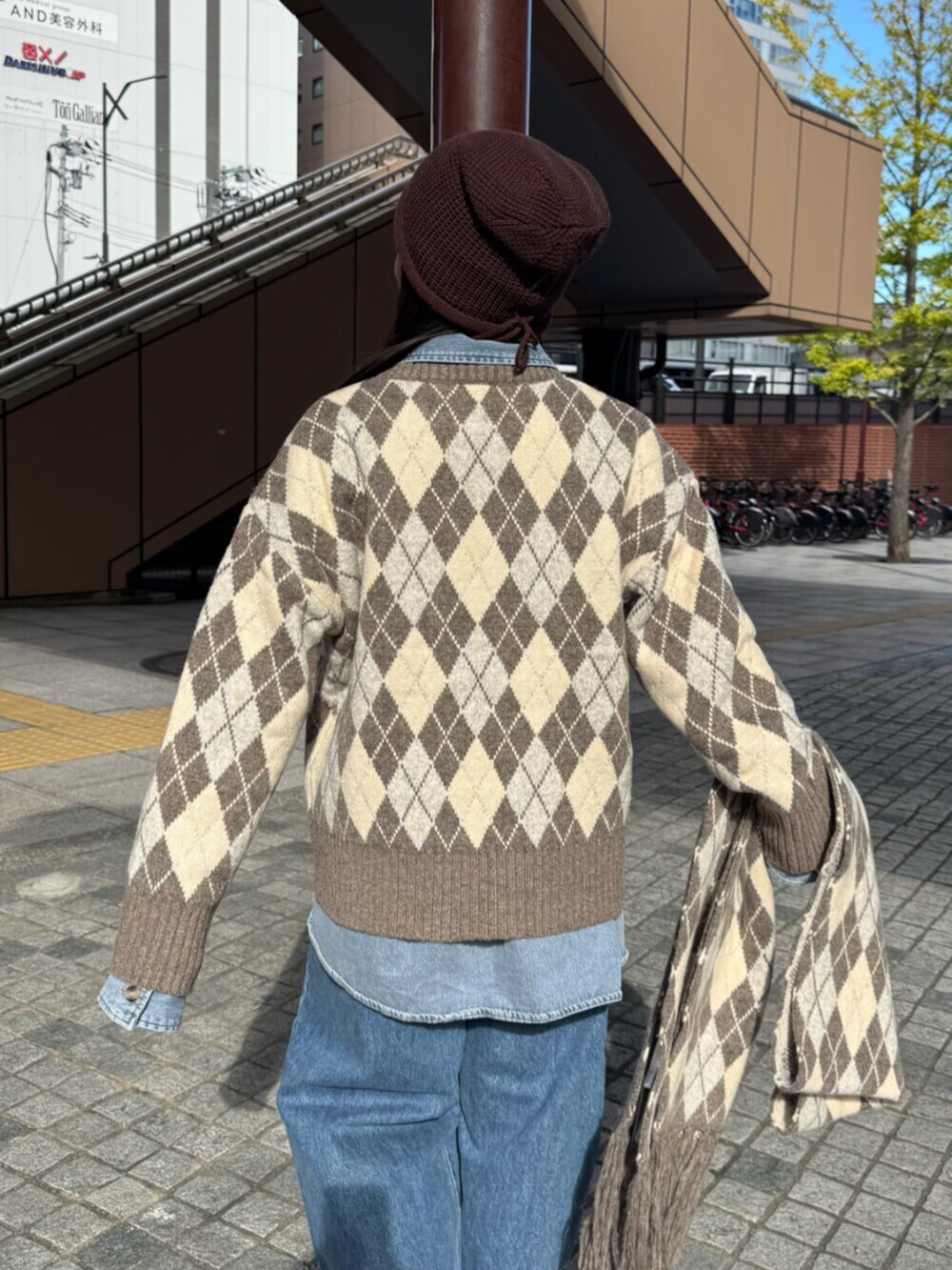 ベージュ系のニット/セーター、ブルー系のシャツ/ブラウス、ブルー系のデニムパンツを着用したレディースの秋コーディネートの7枚目の写真