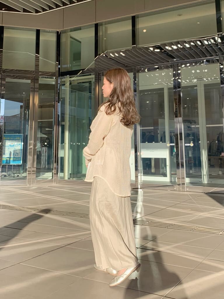 ホワイト系のハンドバッグ、ベージュ系のスカート、ホワイト系のTシャツ/カットソーを着用したレディースの春コーディネートの3枚目の写真