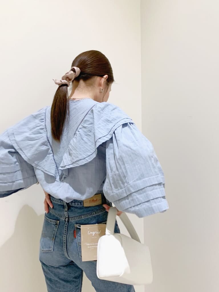 ブルー系のデニムパンツ、ブルー系のシャツ/ブラウス、ホワイト系のハンドバッグを着用したレディースの冬コーディネートの5枚目の写真