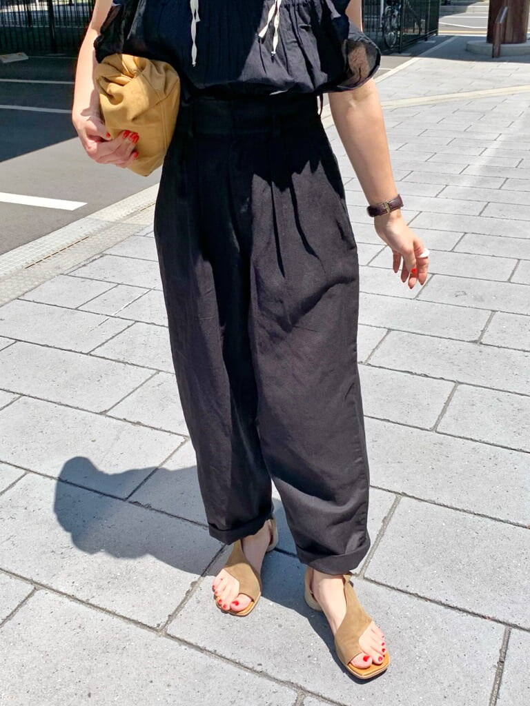 ブラック系のその他パンツ、ベージュ系のクラッチバッグ、ブラウン系のサンダルを着用したレディースの夏コーディネートの6枚目の写真