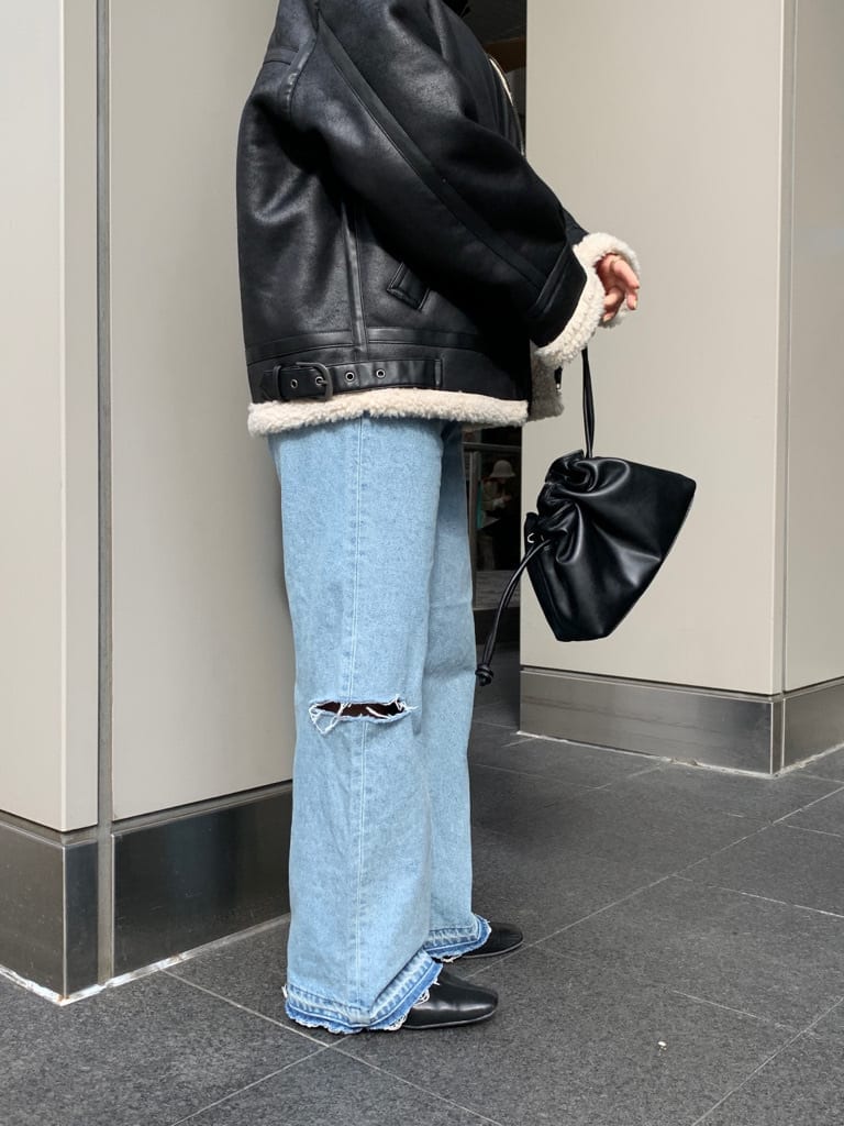 レッド系のニット/セーター、ブラック系のクラッチバッグ、ブラック系のムートンコートを着用したレディースの秋コーディネートの3枚目の写真