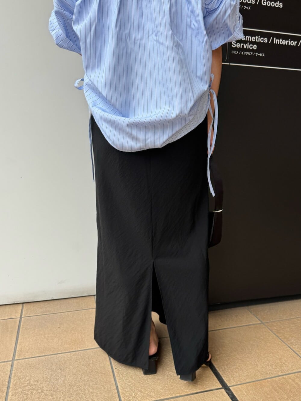 ブラック系のハンドバッグ、ブルー系のシャツ/ブラウス、ブラック系のスカートを着用したレディースの夏コーディネートの9枚目の写真