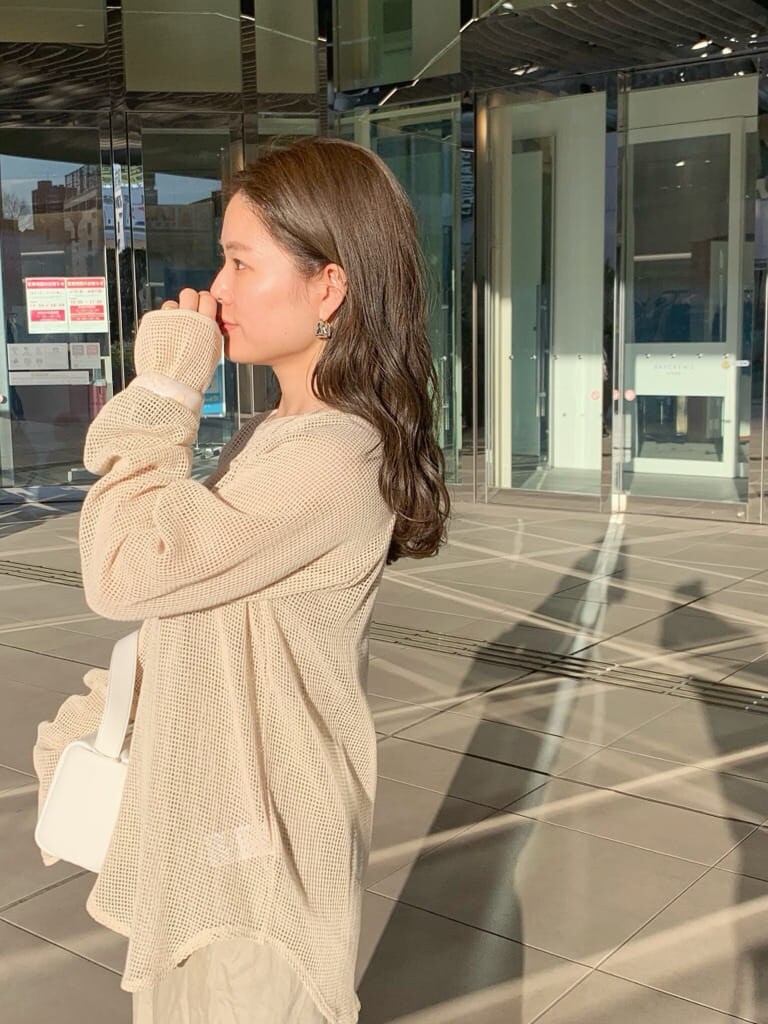 ホワイト系のハンドバッグ、ベージュ系のスカート、ホワイト系のTシャツ/カットソーを着用したレディースの春コーディネートの5枚目の写真