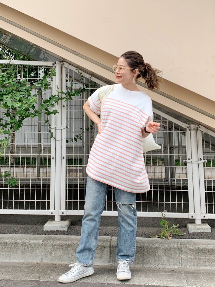 ホワイト系のハンドバッグ、ブルー系のデニムパンツ、ピンク系のTシャツ/カットソーを着用したレディースの夏コーディネートの2枚目の写真