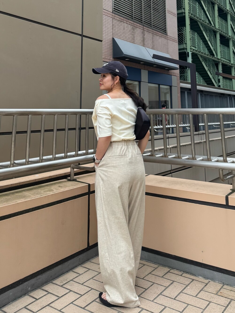 ホワイト系のTシャツ/カットソー、ベージュ系のその他パンツ、ブラック系のハンドバッグを着用したレディースの夏コーディネートの5枚目の写真