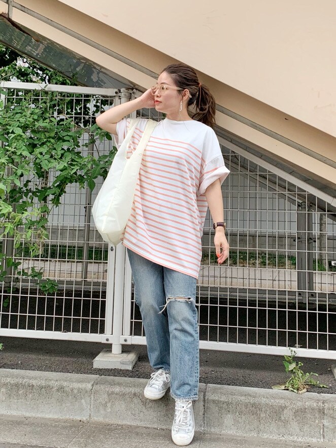 ホワイト系のハンドバッグ、ブルー系のデニムパンツ、ピンク系のTシャツ/カットソーを着用したレディースの夏コーディネートの3枚目の写真