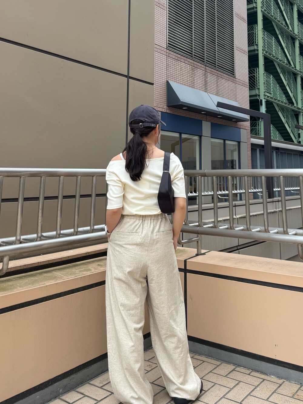 ホワイト系のTシャツ/カットソー、ベージュ系のその他パンツ、ブラック系のハンドバッグを着用したレディースの夏コーディネートの4枚目の写真