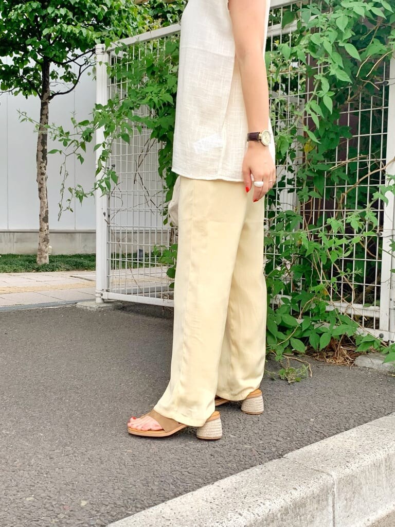 ホワイト系のクラッチバッグ、ホワイト系のシャツ/ブラウス、ブラウン系のサンダルを着用したレディースの夏コーディネートの6枚目の写真