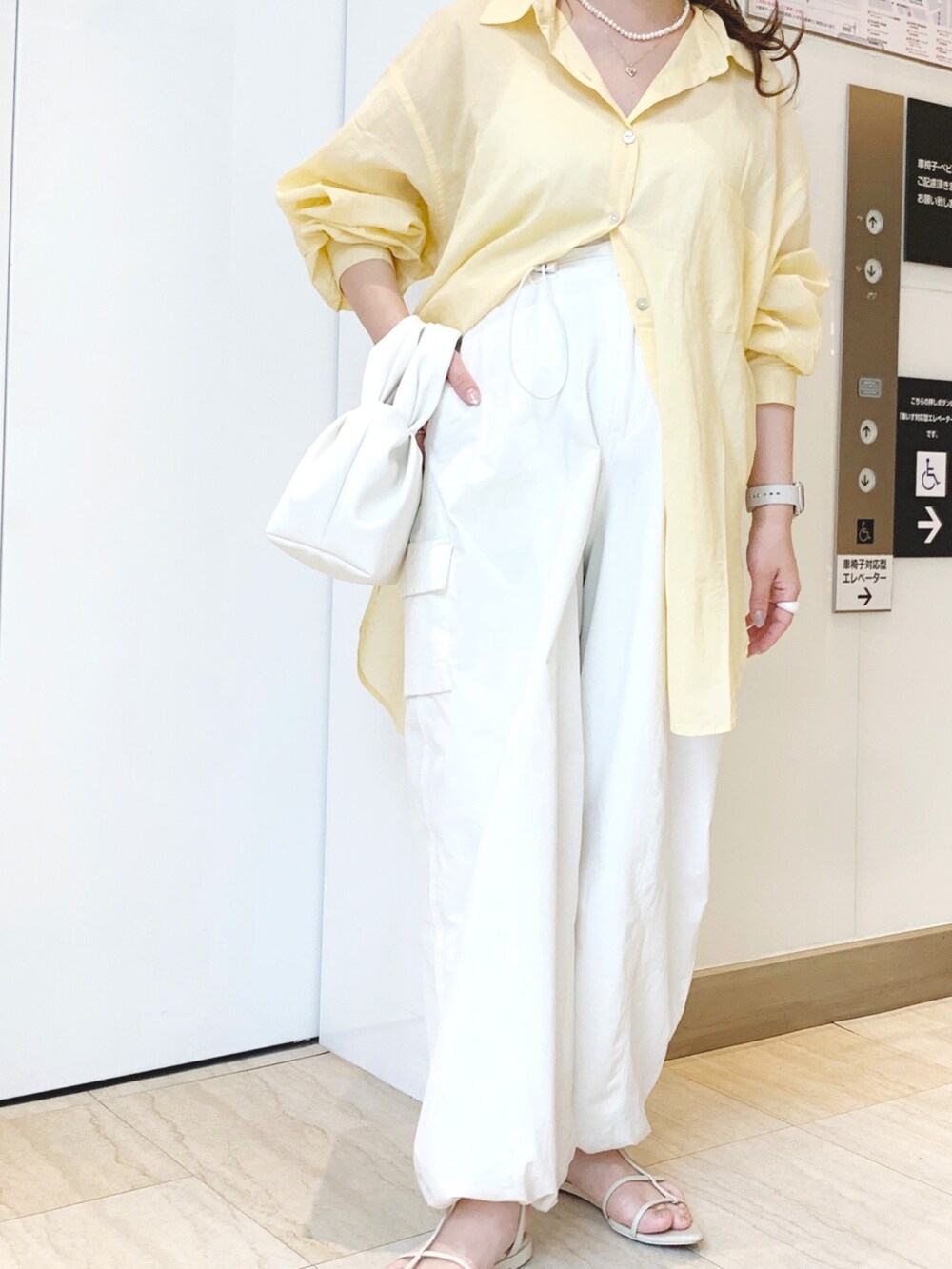 イエロー系のシャツ/ブラウス、ホワイト系のカーゴパンツ、ホワイト系のハンドバッグを着用したレディースの春コーディネートの4枚目の写真