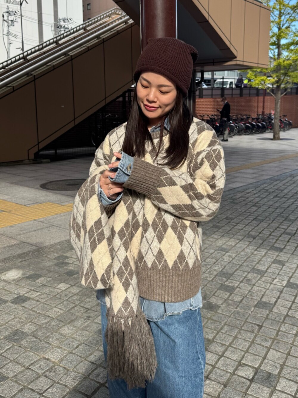 ベージュ系のニット/セーター、ブルー系のシャツ/ブラウス、ブルー系のデニムパンツを着用したレディースの秋コーディネートの5枚目の写真