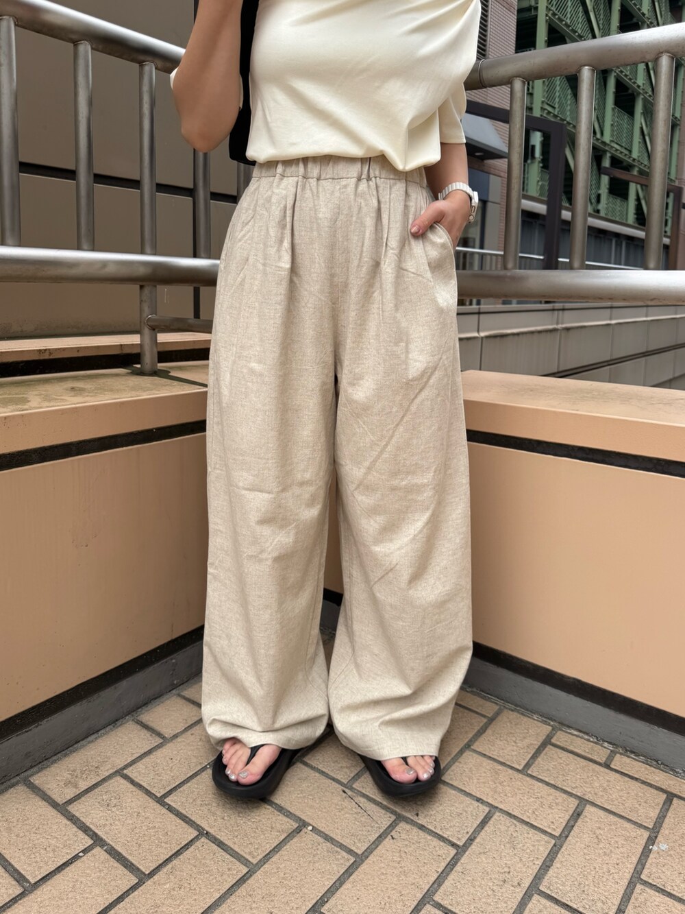 ホワイト系のTシャツ/カットソー、ベージュ系のその他パンツ、ブラック系のハンドバッグを着用したレディースの夏コーディネートの8枚目の写真