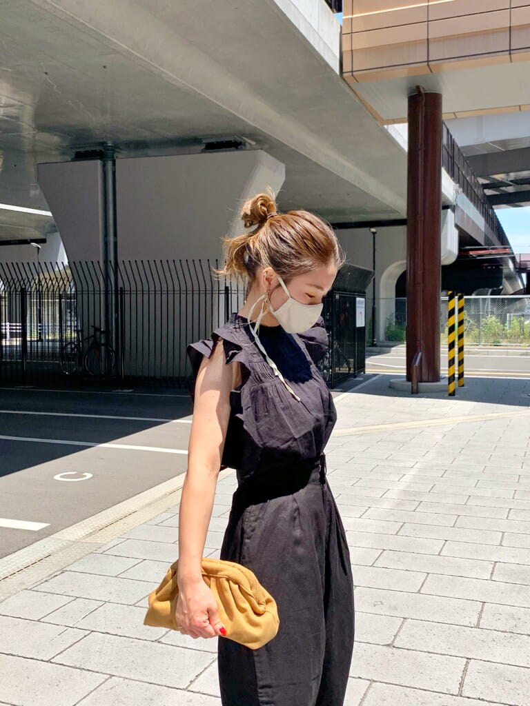 ブラック系のその他パンツ、ベージュ系のクラッチバッグ、ブラウン系のサンダルを着用したレディースの夏コーディネートの3枚目の写真