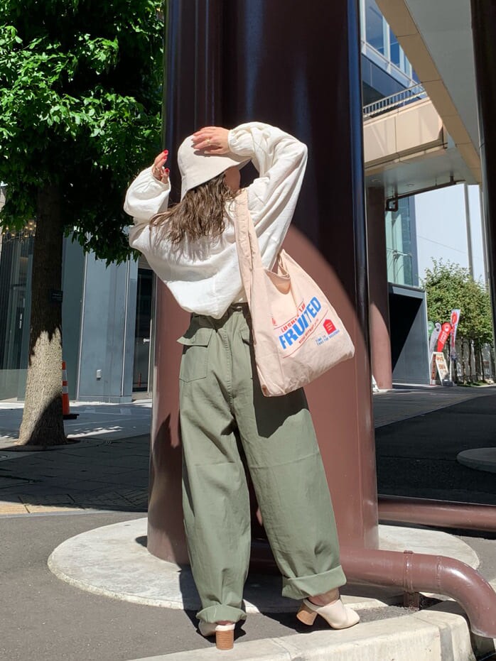 ベージュ系のその他パンツ、ホワイト系のシャツ/ブラウス、ベージュ系のエコバッグ/サブバッグを着用したレディースの夏コーディネートの3枚目の写真