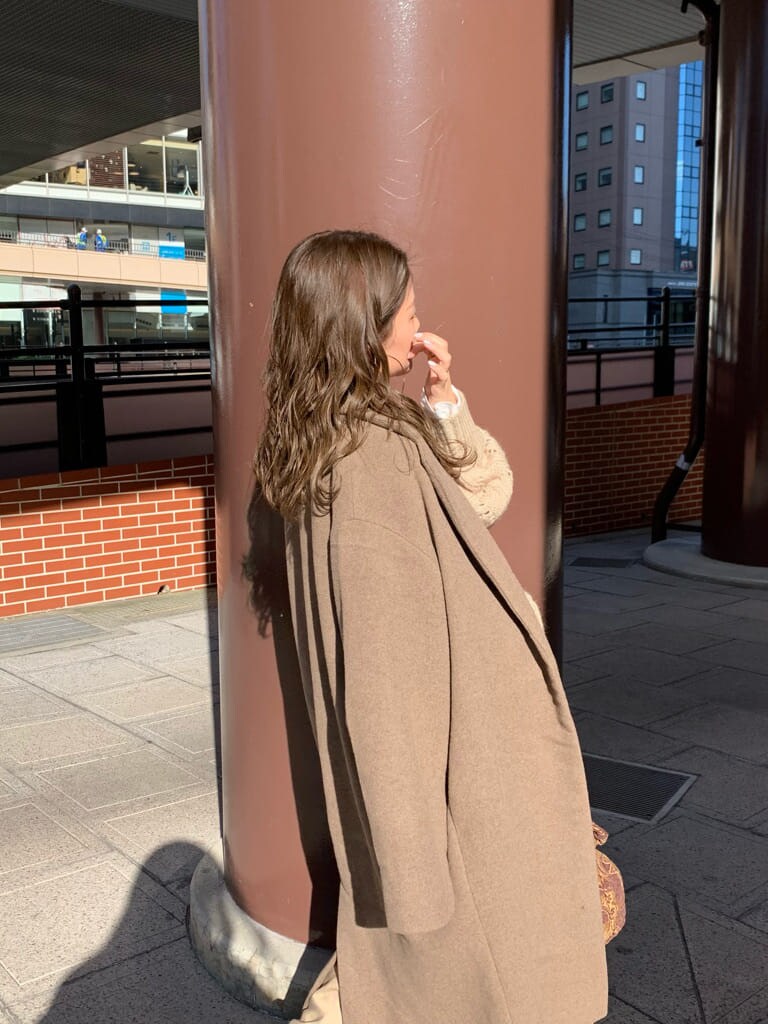 ベージュ系のスカート、ベージュ系のニット/セーター、ブラウン系のハンドバッグを着用したレディースの秋コーディネートの4枚目の写真