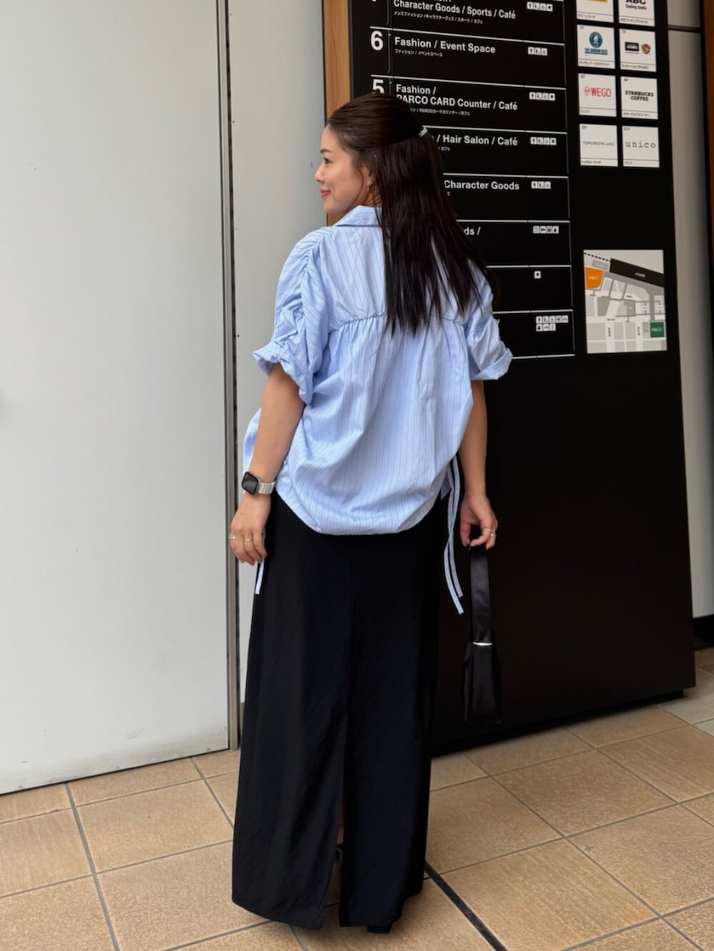 ブラック系のハンドバッグ、ブルー系のシャツ/ブラウス、ブラック系のスカートを着用したレディースの夏コーディネートの4枚目の写真