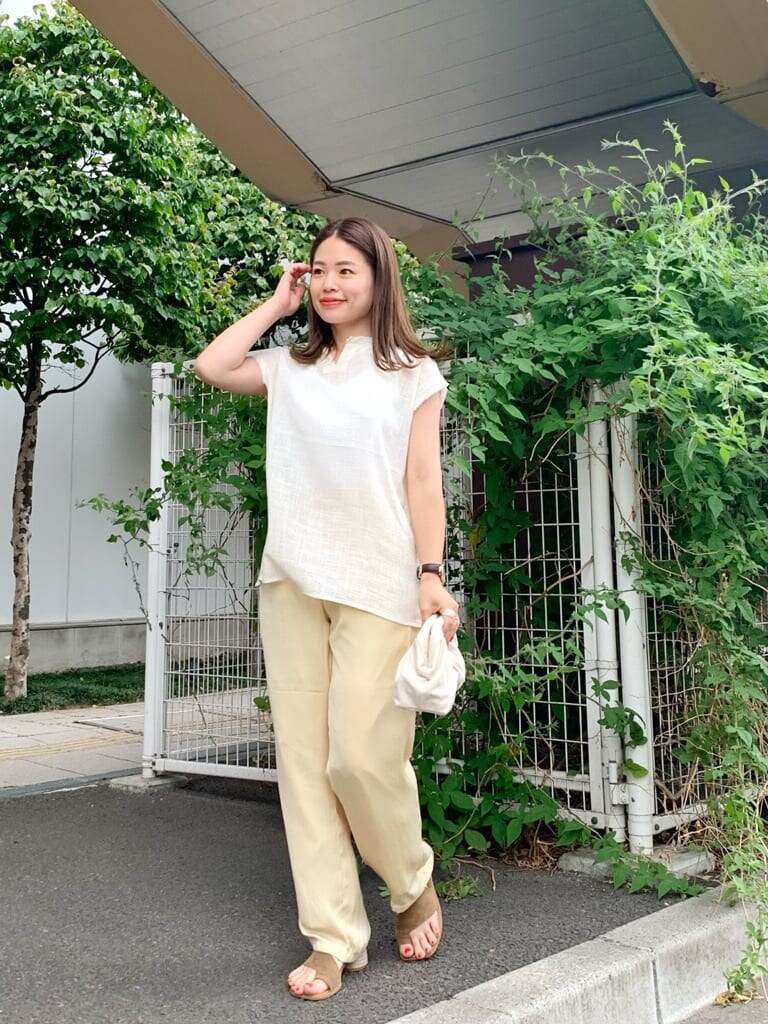 ホワイト系のクラッチバッグ、ホワイト系のシャツ/ブラウス、ブラウン系のサンダルを着用したレディースの夏コーディネートの2枚目の写真