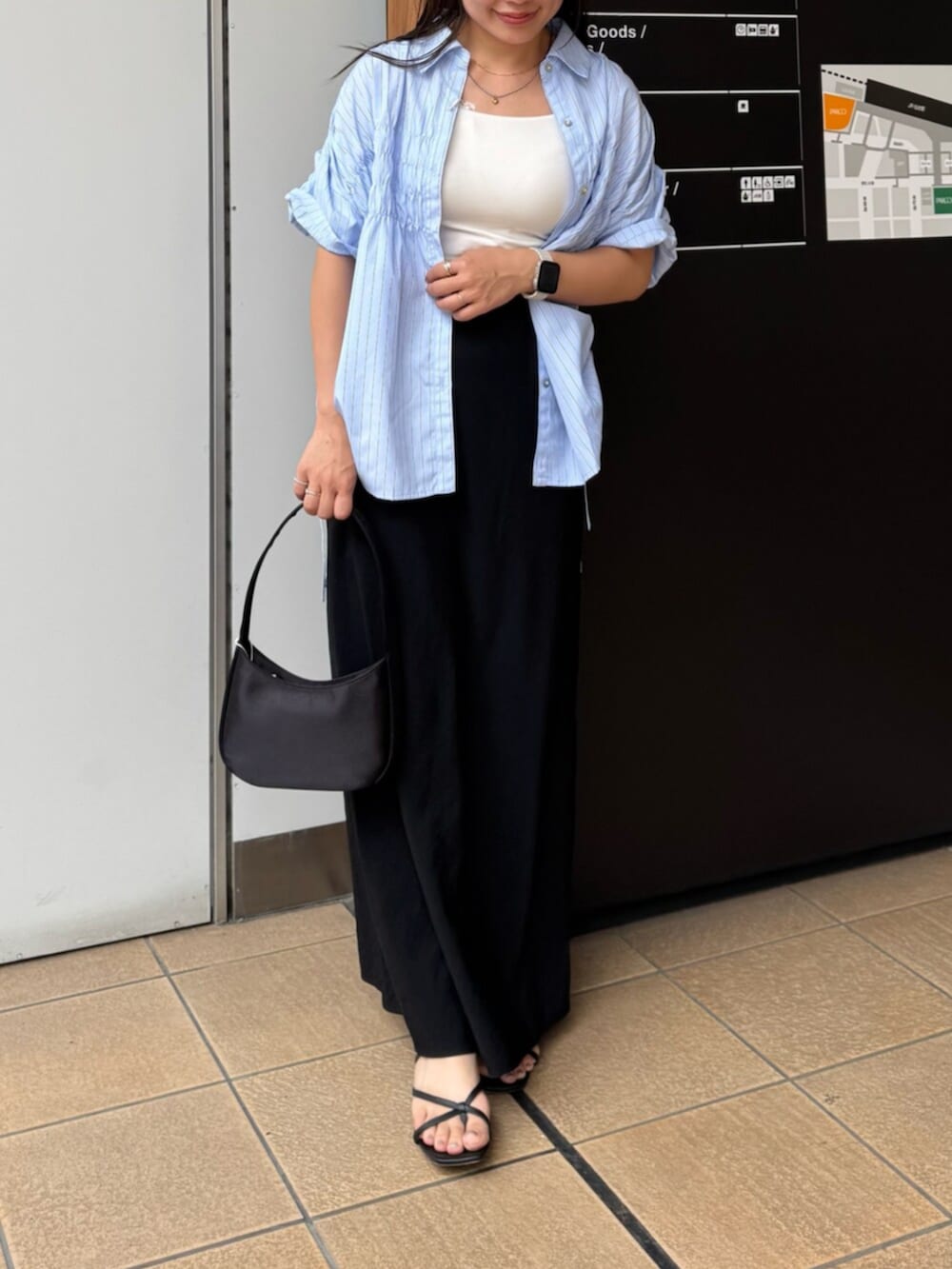 ブラック系のハンドバッグ、ブルー系のシャツ/ブラウス、ブラック系のスカートを着用したレディースの夏コーディネートの5枚目の写真