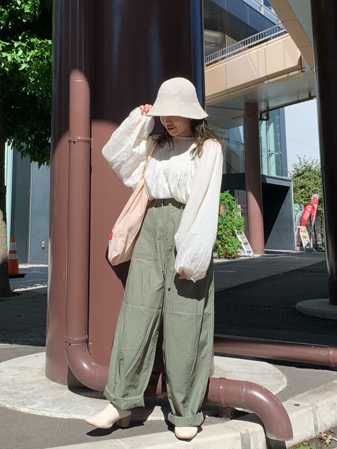 ベージュ系のその他パンツ、ホワイト系のシャツ/ブラウス、ベージュ系のエコバッグ/サブバッグを着用したレディースの夏コーディネートの2枚目の写真
