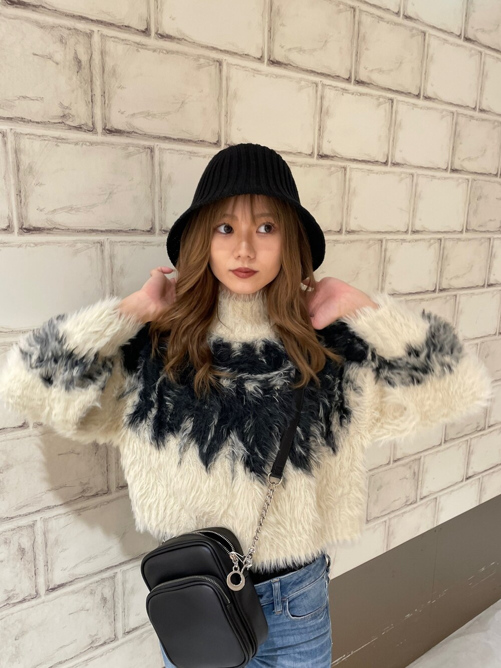 ホワイト系のニット/セーター、ブラウン系のブーツ、ブラック系のハットを着用したレディースの秋コーディネートの5枚目の写真