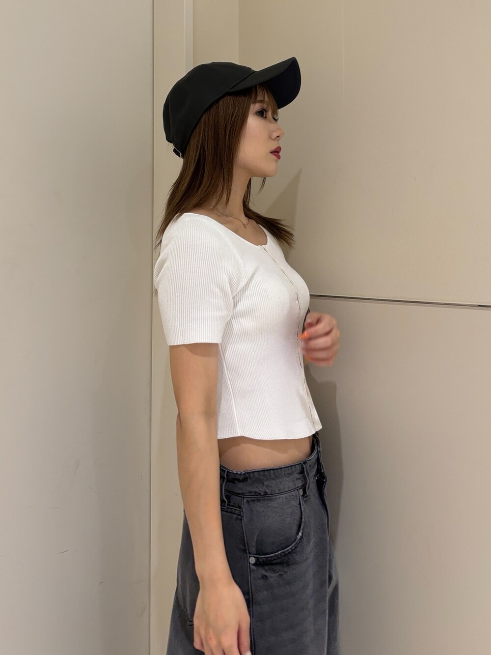 ブラック系のサンダル、ブラック系のデニムパンツ、ホワイト系のニット/セーターを着用したレディースの夏コーディネートの7枚目の写真