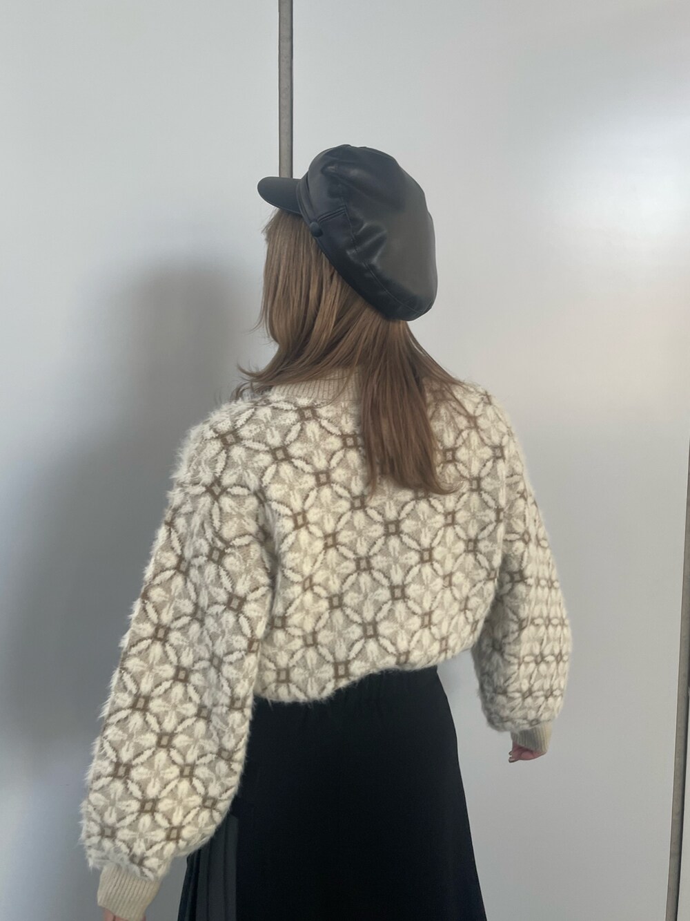 ホワイト系のニット/セーター、ブラック系のスカートを着用したレディースの冬コーディネートの6枚目の写真