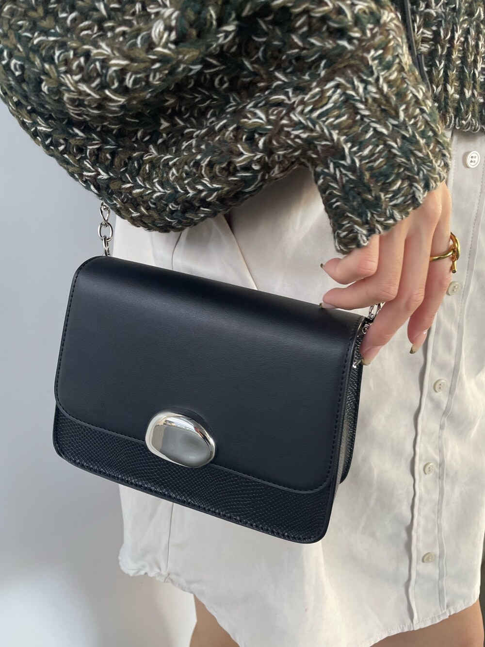 グリーン系のワンピース、ブラック系のショルダーバッグ、ブラック系のブーツを着用したレディースの秋コーディネートの7枚目の写真