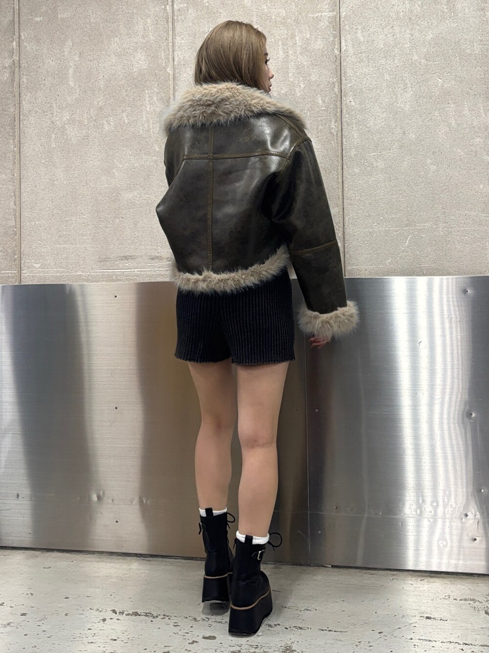 ブラック系のブーツ、ブラック系のその他パンツ、グリーン系のムートンコートを着用したレディースの秋コーディネートの4枚目の写真