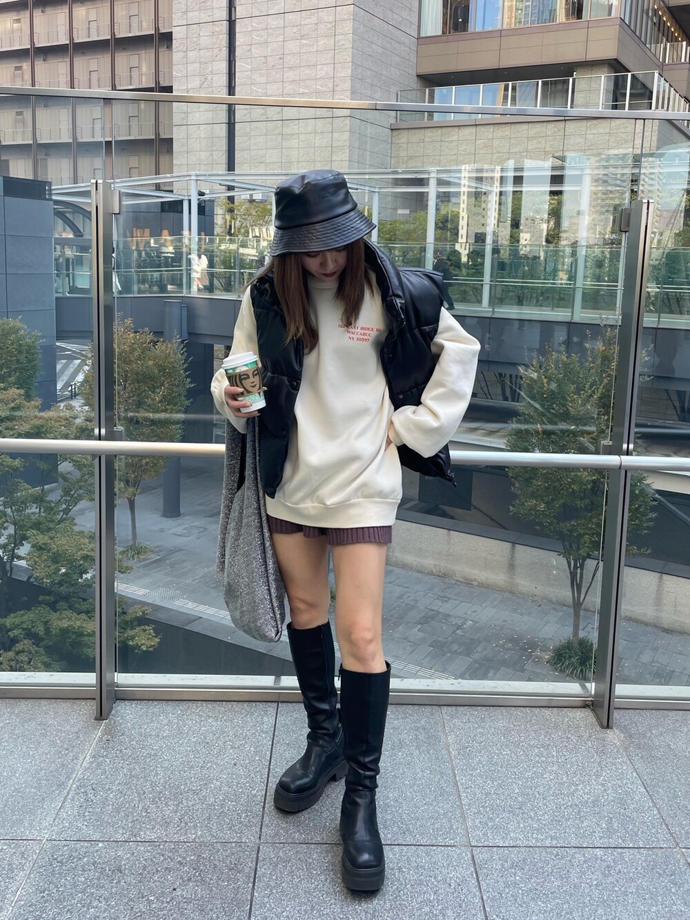 ホワイト系のスウェット、ブラック系のブーツ、ブラック系のハットを着用したレディースの秋コーディネートの5枚目の写真