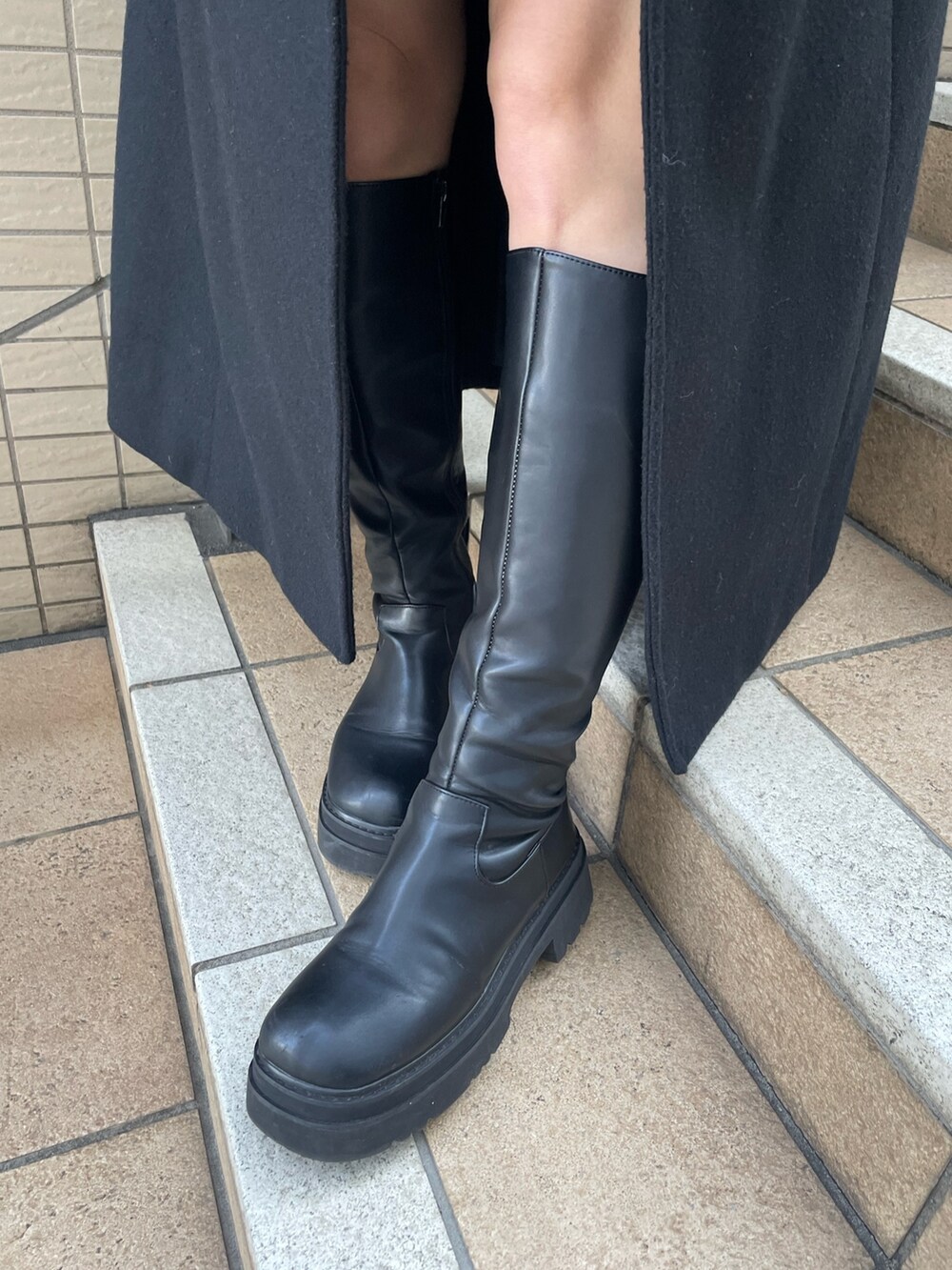 ブラック系のダウンジャケット/コート、ブラック系のブーツ、ベージュ系のハットを着用したレディースの冬コーディネートの10枚目の写真