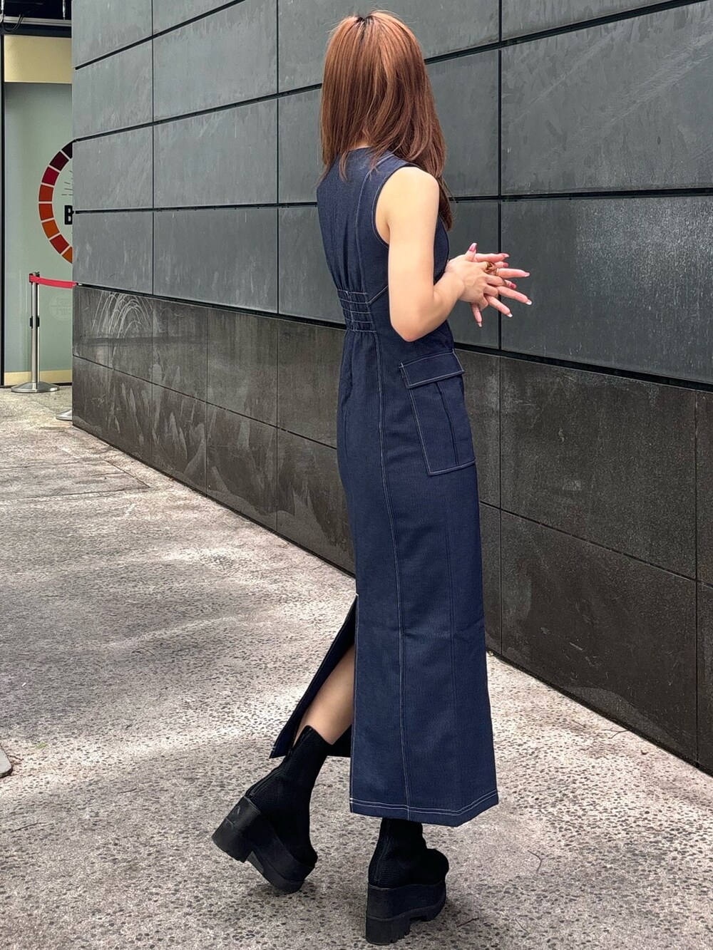 ブルー系のワンピース、ブラック系のブーツを着用したレディースの春コーディネートの4枚目の写真