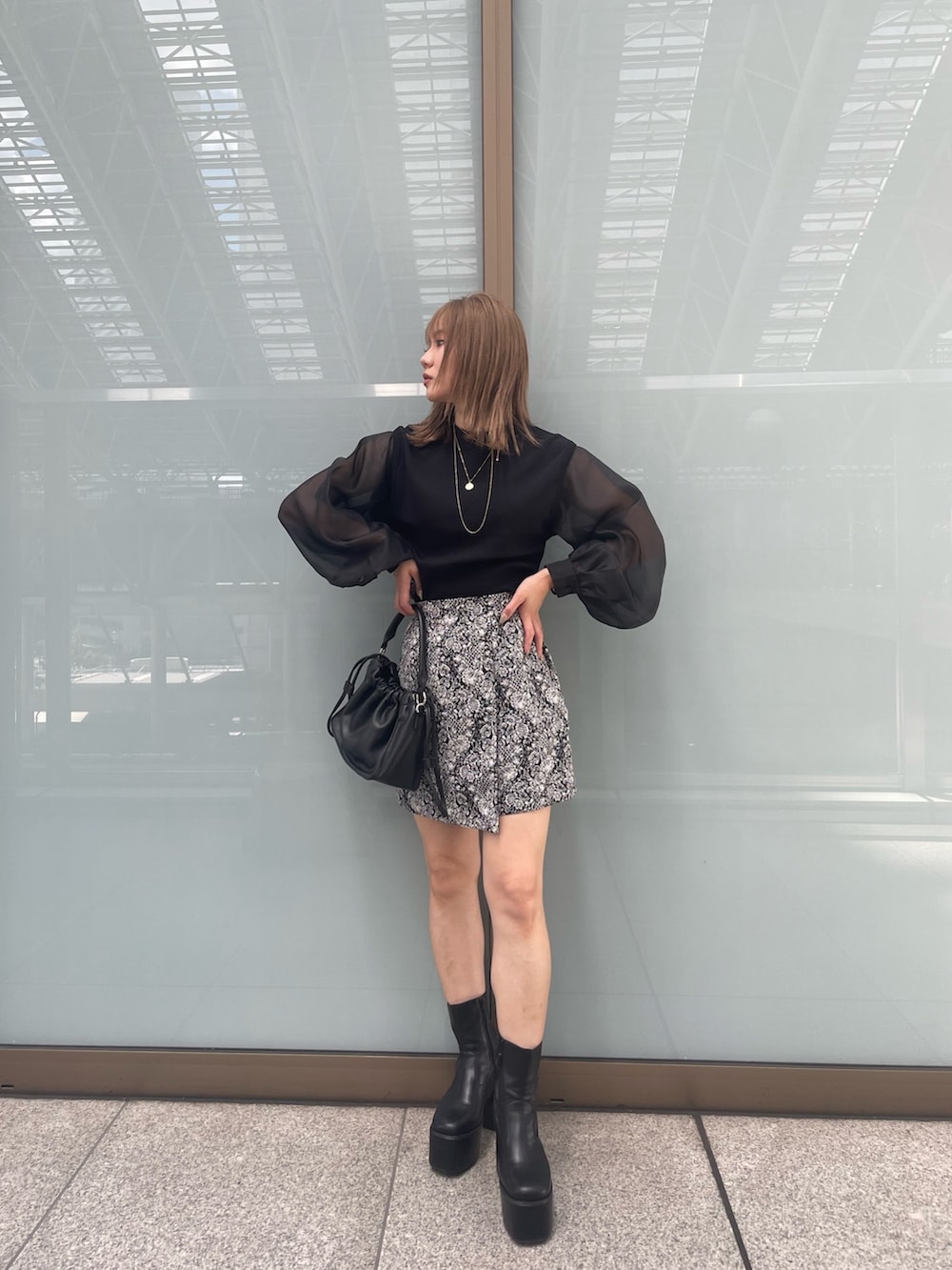 ブラック系のニット/セーター、ブラック系のブーツ、ブラック系のスカートを着用したレディースの夏コーディネートの3枚目の写真
