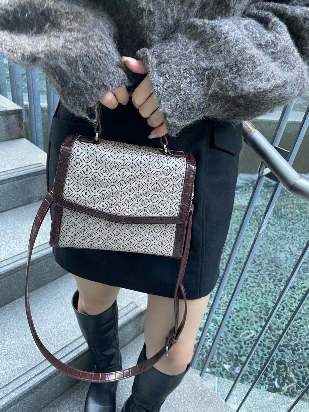 ブラウン系のニット/セーター、ブラック系のスカート、その他のハンドバッグを着用したレディースの秋コーディネートの9枚目の写真