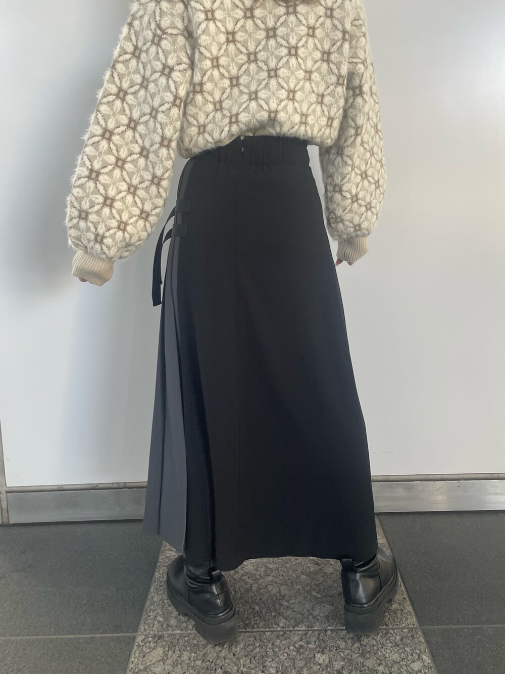 ホワイト系のニット/セーター、ブラック系のスカートを着用したレディースの冬コーディネートの9枚目の写真